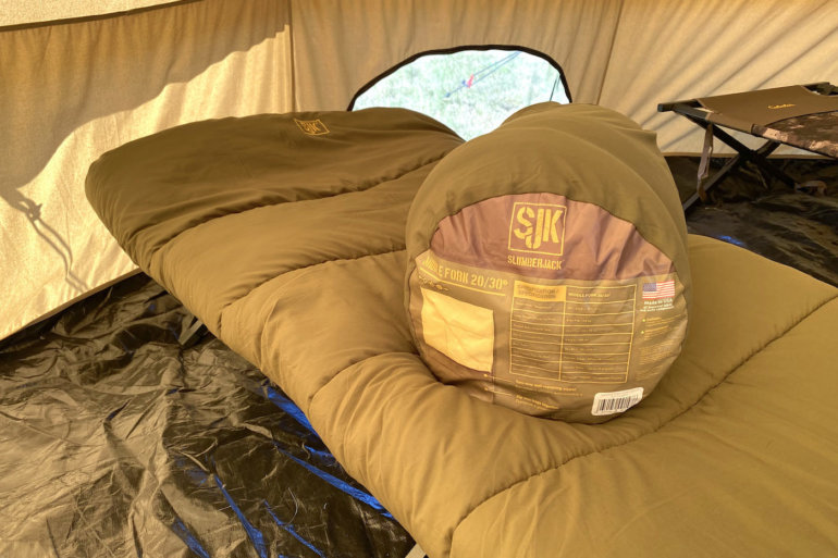 This photo shows the SJK Middle Fork 20/30 Sleeping Bag on a cot inside of a tent.