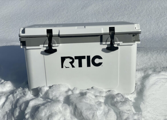 This photo shows the RTIC 32 QT Ultra-Light Cooler with its lid closed outside in snow.