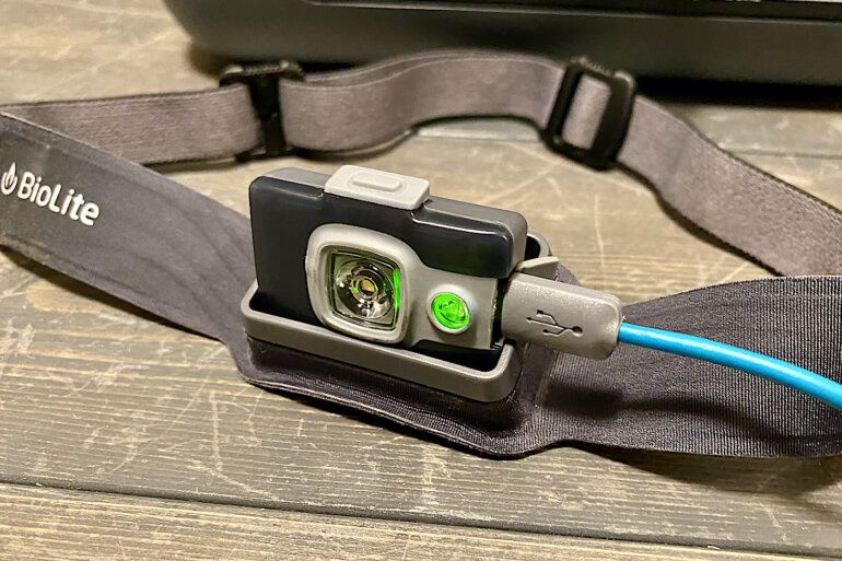 This photo shows the BioLite HeadLamp 325 being charged with a connected usb cord.
