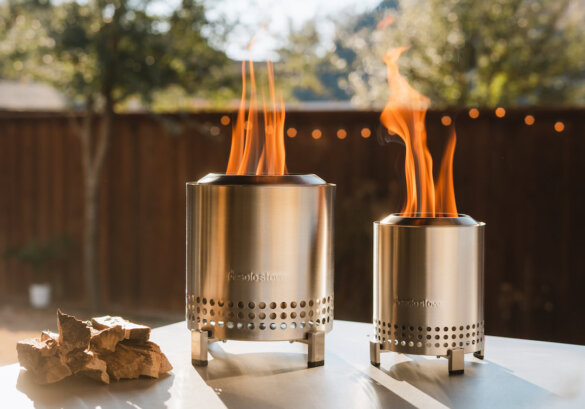 This outdoor gifts for moms photo shows the Solo Stove Mesa and Mesa XL tabletop fire pits outside in use with fire.
