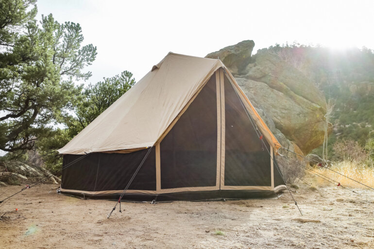 This photo shows the White Duck Regatta 360 Tent set up in a camping environment.