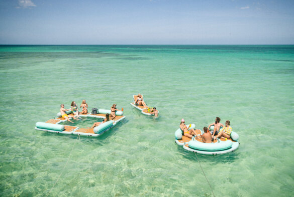 This photo shows people relaxing on the BOTE Hangout Suite in a beautiful ocean environment.