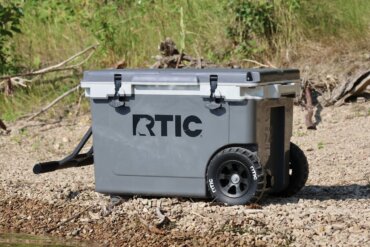 This review photo shows the RTIC 52 QT Ultra-Light Wheeled Cooler on a beach during the testing process.