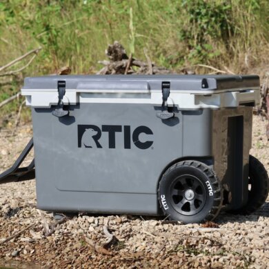 This review photo shows the RTIC 52 QT Ultra-Light Wheeled Cooler on a beach during the testing process.