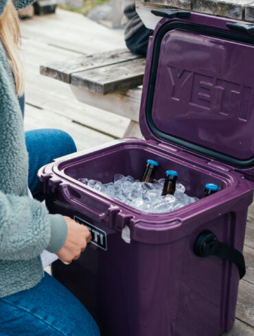 This photo shows the YETI Roadie 24 cooler with ice and bottles inside.