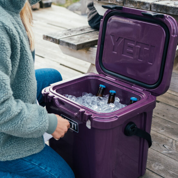This photo shows the YETI Roadie 24 cooler with ice and bottles inside.