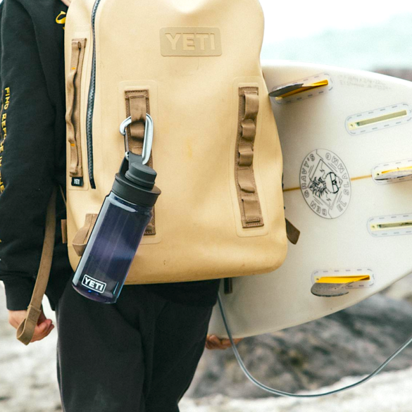 This photo shows a YETI Yonder Water Bottle attached to a backpack.
