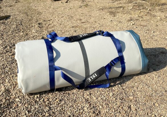 This review photo shows the ISLE Base Camp Dock rolled up with its included carry straps.