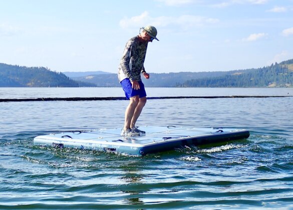 This review photo shows the author standing on the ISLE Base Camp Dock while it's floating on a lake during the testing process.