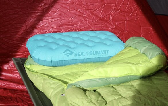 This review photo shows the Sea to Summit Aeros Ultralight Deluxe Pillow inflated on a down sleeping bag used by the author during the testing and review process.