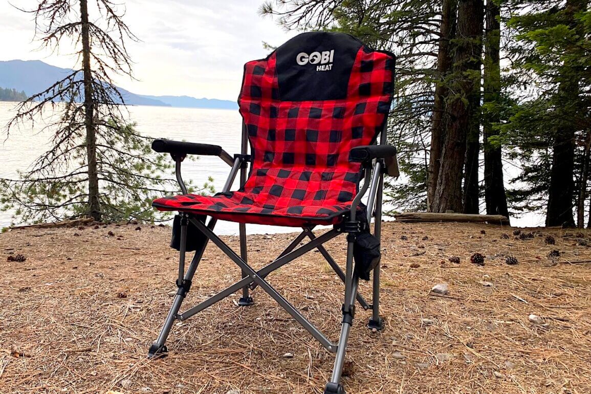 This review photo shows the Gobi Heat Terrain Heated Camping Chair at a camping spot near a lake during the testing process.