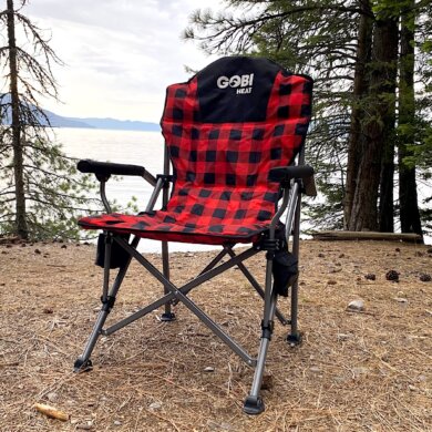 This review photo shows the Gobi Heat Terrain Heated Camping Chair at a camping spot near a lake during the testing process.
