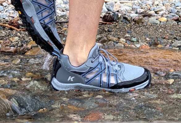 This photo shows the author testing the Korkers All Axis Shoe without socks along a rocky shoreline.