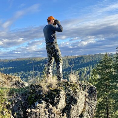 This photo shows the author looking through binoculars while hunting.