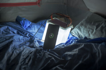 This Amazon Cyber Monday Deals and outdoor favorite gear picks shows the LuminAID PackLite Max 2-in-1 Camping Lantern and Phone Charger in a tent with a phone charging.