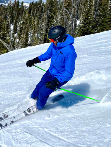 This photo shows the author wearing the Helly Hansen Odin 9 Worlds Jacket while skiing.