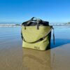 This review photo shows the RUX Waterproof Bag on a wet sandy beach during the testing process.