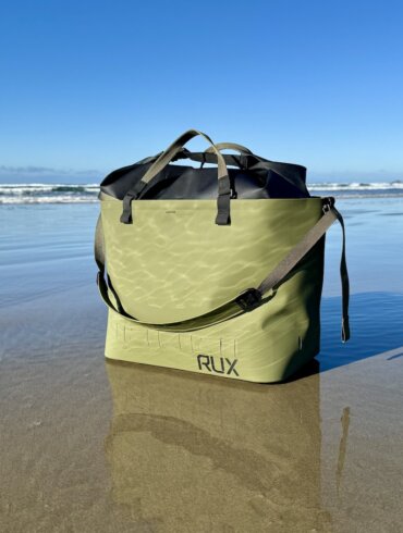 This review photo shows the RUX Waterproof Bag on a wet sandy beach during the testing process.