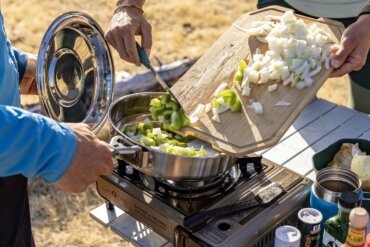 This photo shows the new Gerber ComplEAT Camp Cook Collection being used outdoors to cook a camping meal.