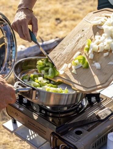This photo shows the new Gerber ComplEAT Camp Cook Collection being used outdoors to cook a camping meal.