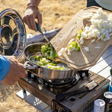 This photo shows the new Gerber ComplEAT Camp Cook Collection being used outdoors to cook a camping meal.