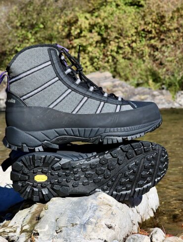 This review photo shows the Patagonia Forra Wading Boots on a rock near a river during the testing process.