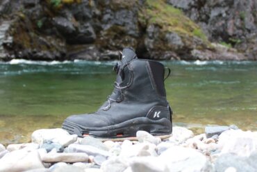 This field-tested review photo shows the Korkers Devil's Canyon Wading Boots near a river.