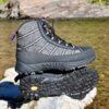 Pair of lightweight wading boots on a rock by a river.