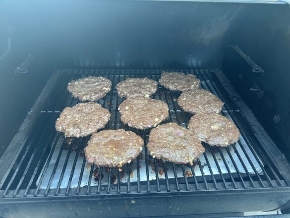 Nine very large elk burgers on a Traeger Pro 575 main grill.