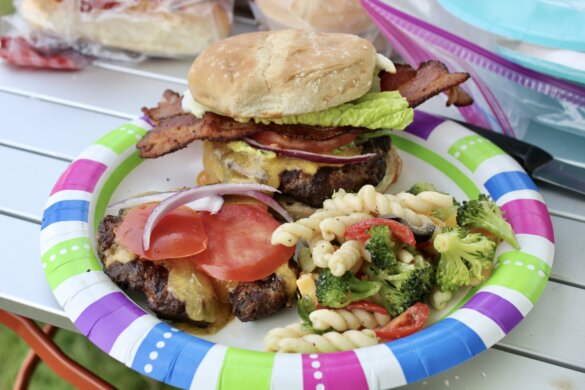Closeup of a bacon burger that was cooked on the Camp Chef Pro 14 60X stove while camping.