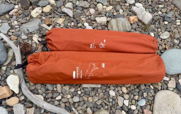 campwell folding cot packed in bag next to packed rei camp chair for size comparison