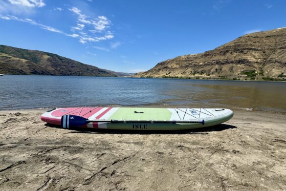 ISLE Pioneer 3 inflated with paddle attached on beach near water.