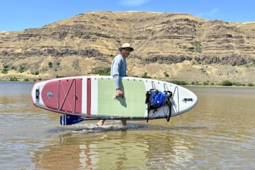 Author Chris Maxcer carries the ISLE Pioneer 3 Paddle Board in the water during the testing and review process.