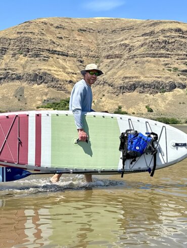 Author Chris Maxcer carries the ISLE Pioneer 3 Paddle Board in the water during the testing and review process.