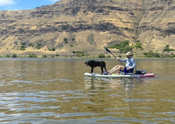Author Chris Maxcer sits on the Pioneer 3 in the kayak configuration with a dog standing on the front of the iSUP.