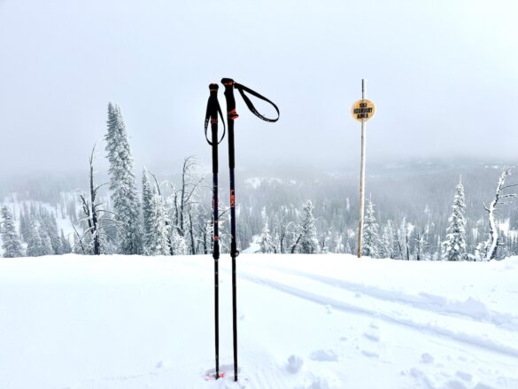 Ski poles standing in snow at the top end of a ski resort in Idaho.