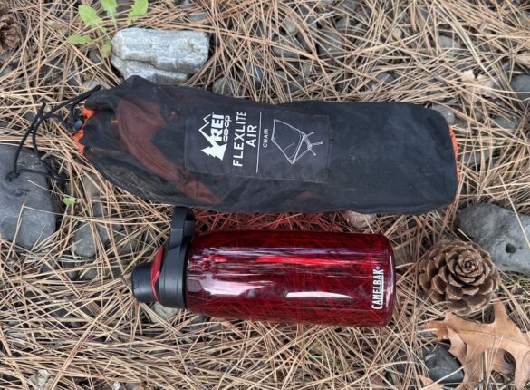 packed rei flexlite air chair next to 1-liter water bottle for size reference