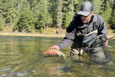 Author Chris Maxcer tests wading boots on the St. Joe River in Idaho while fishing for cutthroat trout.