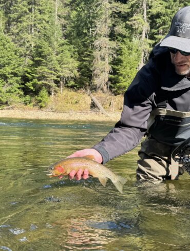 Author Chris Maxcer tests wading boots on the St. Joe River in Idaho while fishing for cutthroat trout.