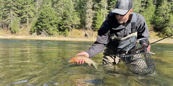 Author Chris Maxcer tests wading boots on the St. Joe River in Idaho while fishing for cutthroat trout.