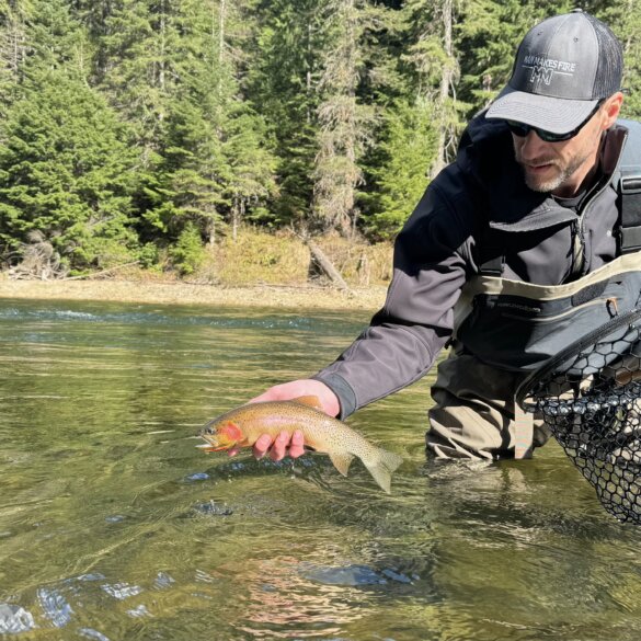 Author Chris Maxcer tests wading boots on the St. Joe River in Idaho while fishing for cutthroat trout.