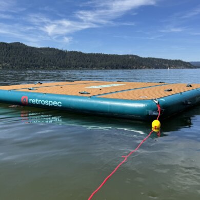Retrospec Siesta Dock XL Inflatable Platform 10' floating on a mountain lake with an anchor rope attached.