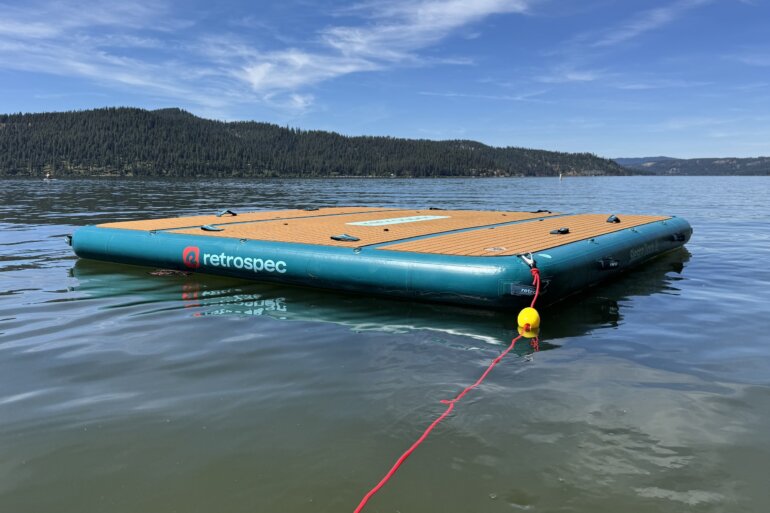 Retrospec Siesta Dock XL Inflatable Platform 10' floating on a mountain lake with an anchor rope attached.