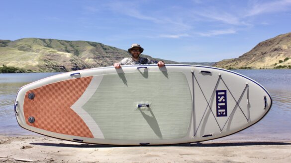 The author stands at the edge of a beach next to the extra large ISLE Megalodon iSUP floating dock alternative.