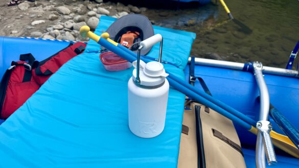 Half-gallon RTIC Outback Jug shown on a whitewater raft on a summer rafting trip during the testing and review process.