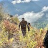 The author climbs a hill while carrying his bow while elk hunting in the mountains of Idaho.