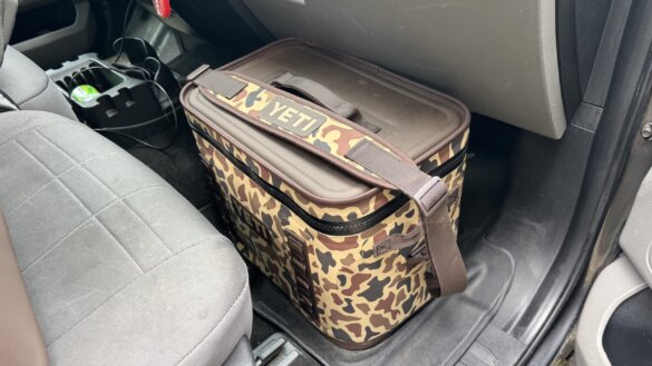 YETI Hopper Flip 18 soft cooler shown in the footwell of the front passenger seating area of a pickup truck.